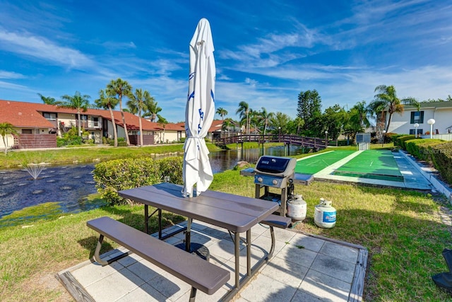 view of property's community with a lawn and a water view