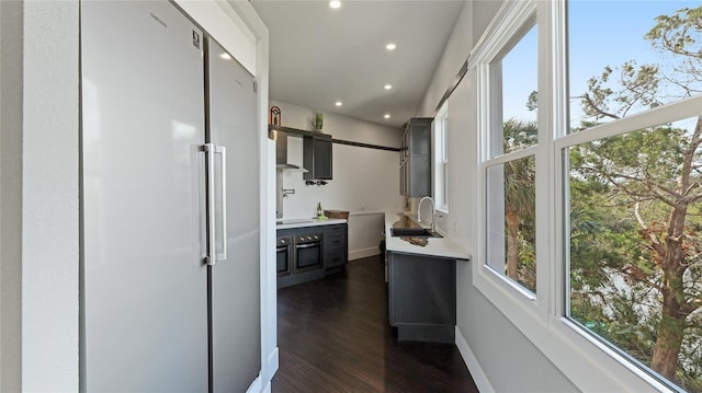 corridor with sink and dark wood-type flooring