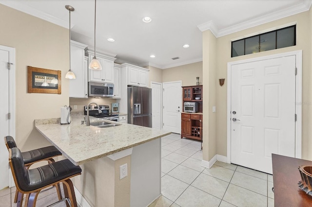 kitchen with a kitchen breakfast bar, kitchen peninsula, pendant lighting, white cabinets, and appliances with stainless steel finishes