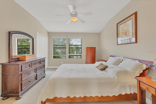 bedroom with ceiling fan, a closet, light carpet, and lofted ceiling