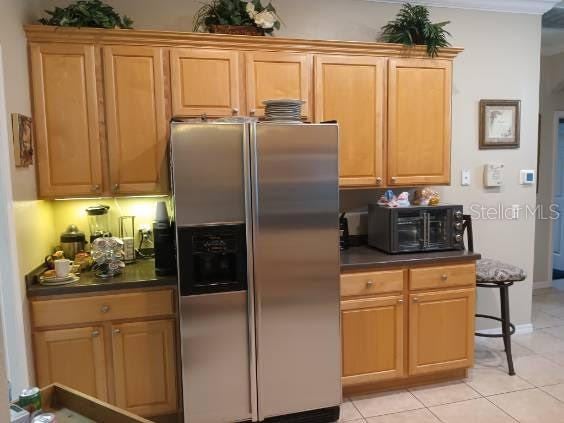 kitchen with stainless steel refrigerator with ice dispenser and light tile patterned floors