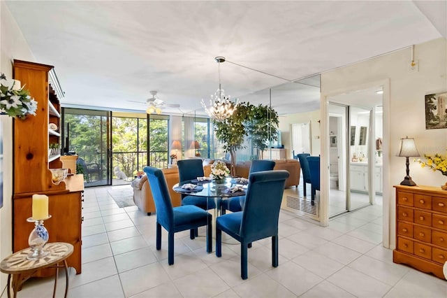 tiled dining space featuring ceiling fan with notable chandelier and a wall of windows