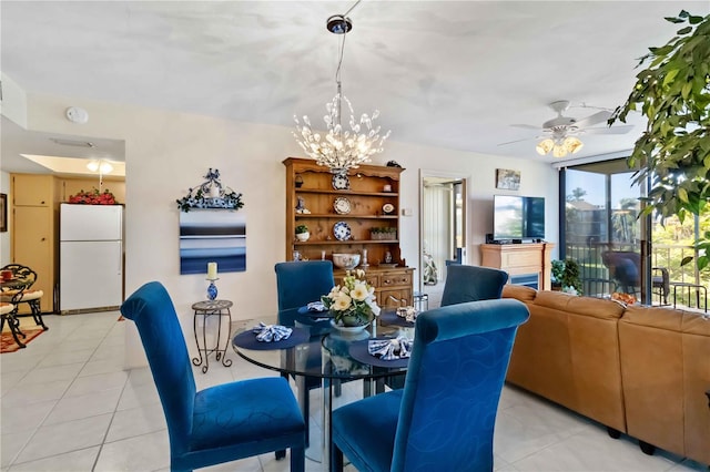 dining space with light tile patterned floors and ceiling fan with notable chandelier