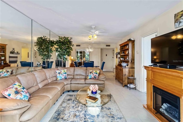 tiled living room featuring ceiling fan with notable chandelier