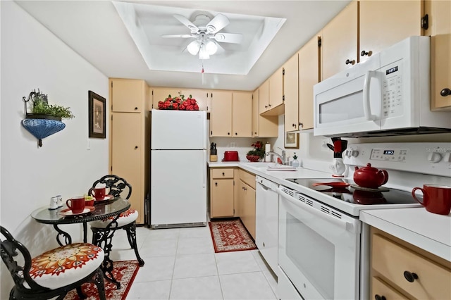 kitchen featuring ceiling fan, sink, a raised ceiling, white appliances, and light tile patterned floors