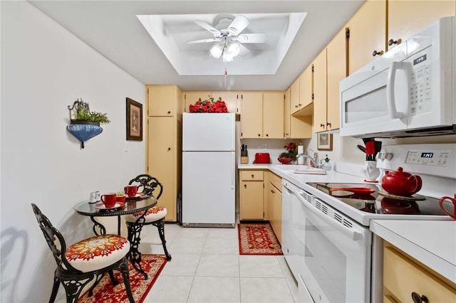 kitchen with white appliances, a raised ceiling, sink, ceiling fan, and light tile patterned flooring