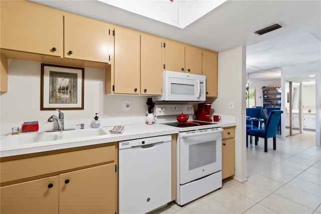 kitchen featuring light tile patterned flooring, light brown cabinets, white appliances, and sink