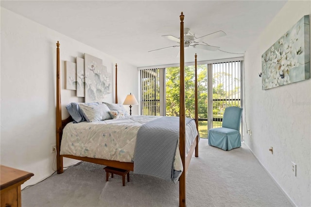 carpeted bedroom with ceiling fan, expansive windows, and access to exterior