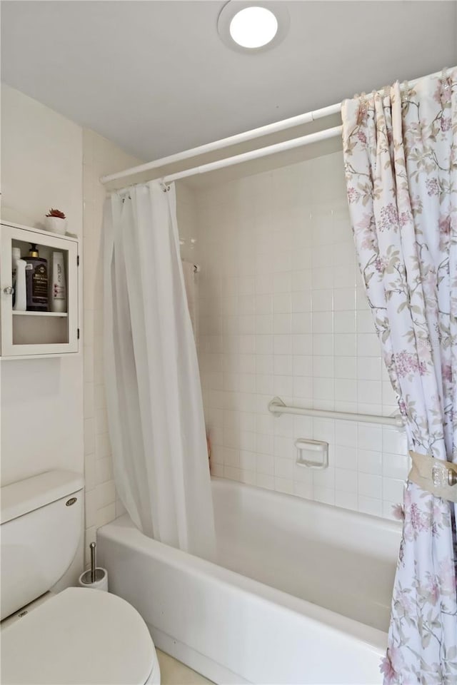 bathroom with toilet and shower / bath combo with shower curtain