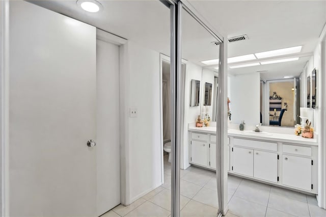 bathroom featuring tile patterned floors, vanity, and toilet