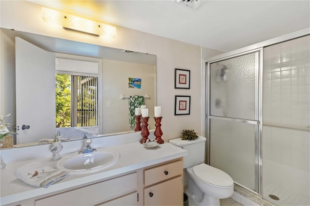 bathroom with vanity, an enclosed shower, and toilet