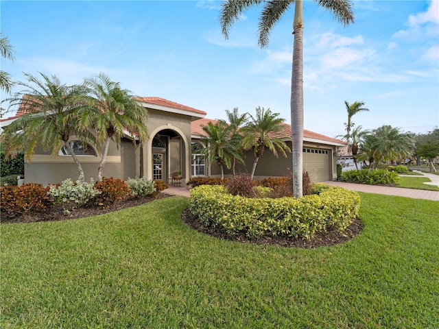 mediterranean / spanish home with a garage and a front lawn