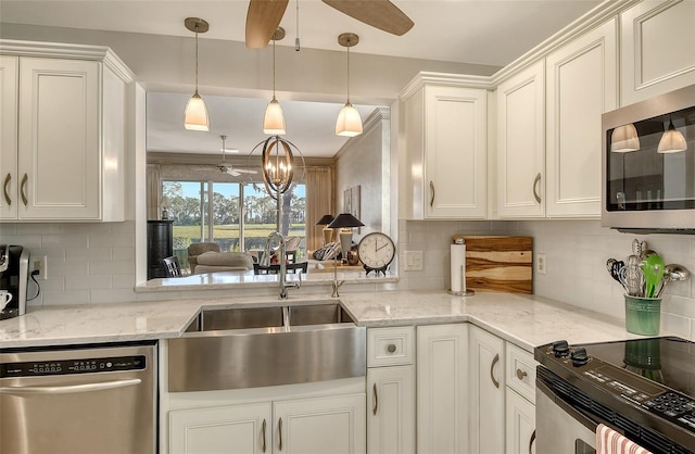 kitchen with white cabinetry, sink, stainless steel appliances, decorative light fixtures, and decorative backsplash