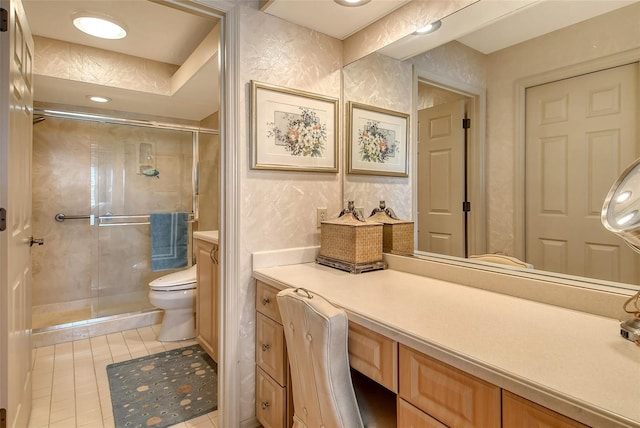 bathroom featuring tile patterned floors, vanity, toilet, and a shower with door