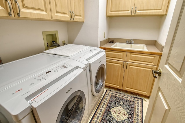 laundry room featuring washer and clothes dryer, sink, and cabinets