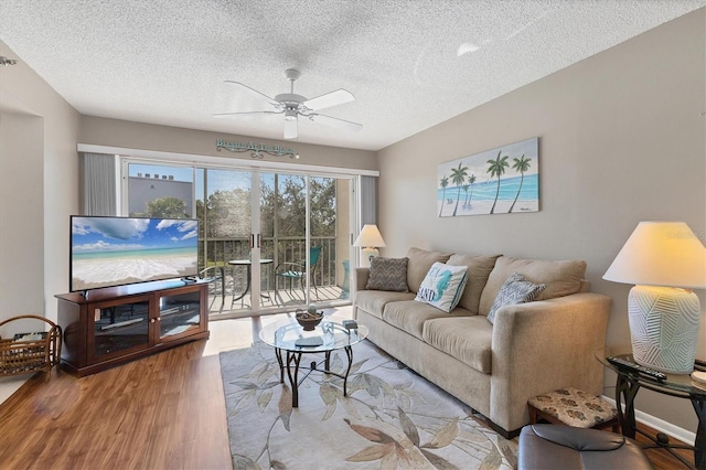 living room featuring a textured ceiling, light hardwood / wood-style floors, and ceiling fan