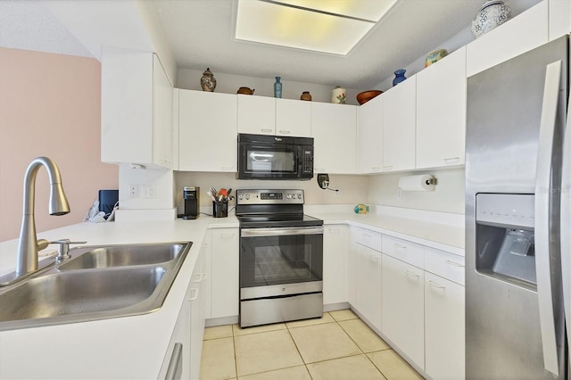 kitchen with white cabinets, light tile patterned floors, stainless steel appliances, and sink