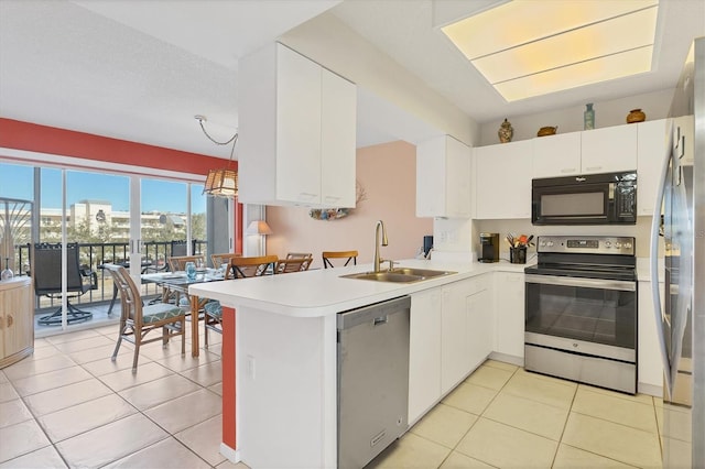 kitchen featuring pendant lighting, white cabinets, sink, kitchen peninsula, and stainless steel appliances