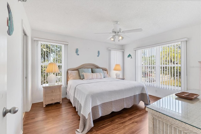 bedroom featuring ceiling fan, wood-type flooring, and a textured ceiling