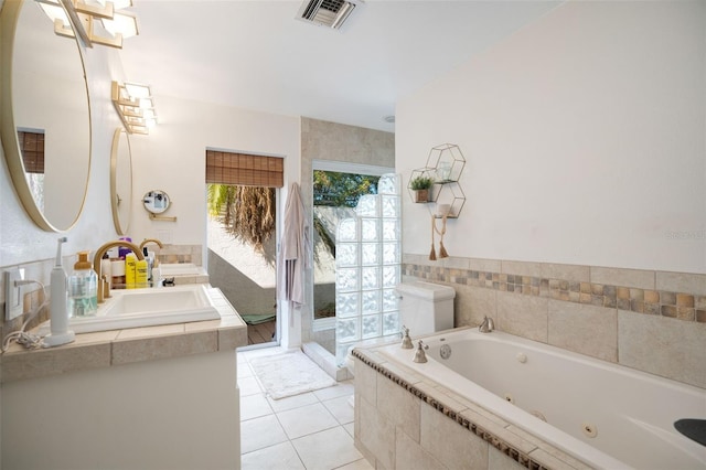 bathroom featuring vanity, a relaxing tiled tub, and tile patterned floors