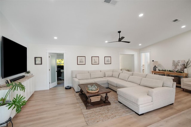 living room featuring vaulted ceiling, ceiling fan, and light wood-type flooring