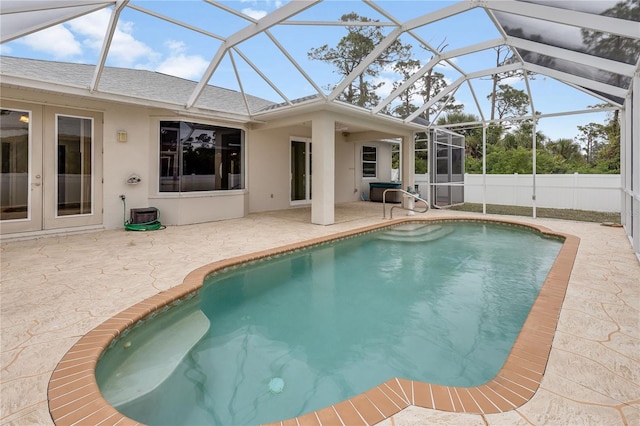 view of pool with glass enclosure, french doors, and a patio