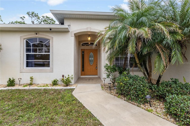 entrance to property featuring a lawn