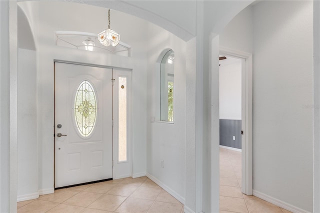 entrance foyer with light tile patterned floors and an inviting chandelier