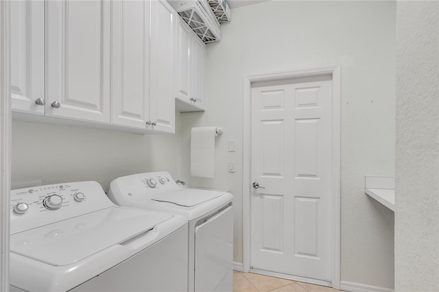 washroom featuring cabinets, washer and clothes dryer, and light tile patterned flooring