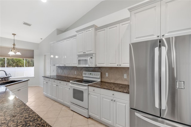 kitchen with lofted ceiling, white cabinets, sink, and white appliances