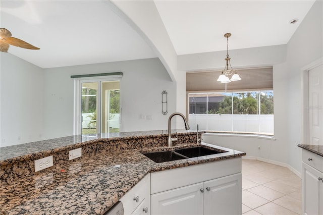 kitchen featuring ceiling fan, sink, light tile patterned flooring, white cabinets, and dark stone counters