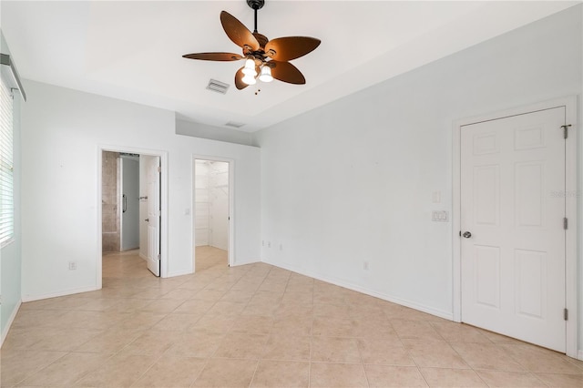 unfurnished bedroom featuring ceiling fan, light tile patterned floors, a spacious closet, and a closet