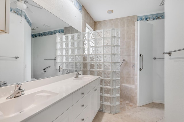 bathroom with ceiling fan, vanity, tile patterned flooring, toilet, and a shower