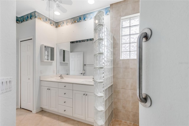 bathroom featuring ceiling fan, vanity, tile patterned floors, and a tile shower