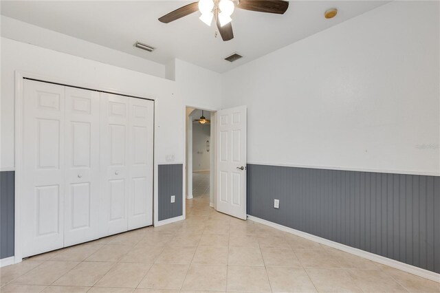 unfurnished bedroom featuring ceiling fan, light tile patterned floors, and a closet