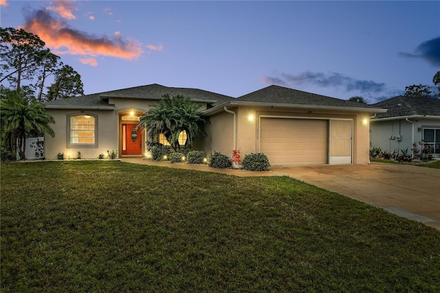 view of front of house with a garage and a lawn