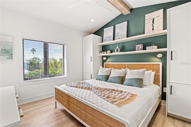 bedroom featuring vaulted ceiling with beams, ceiling fan, and light hardwood / wood-style flooring