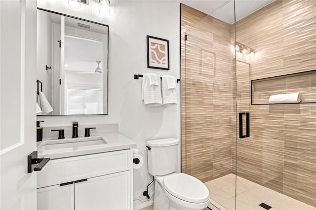 bathroom featuring vanity, a shower with door, toilet, and ceiling fan