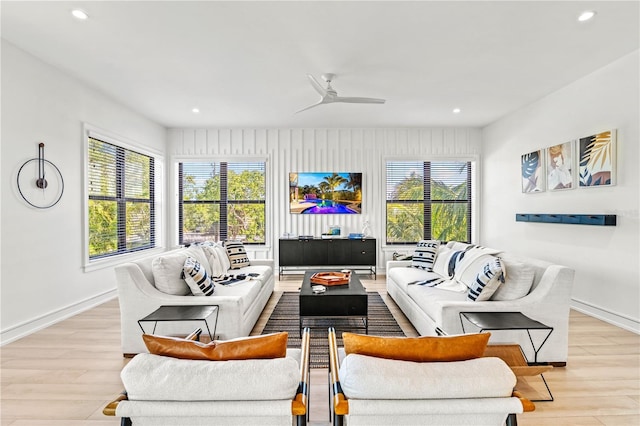 living room with ceiling fan, light wood-type flooring, and a wealth of natural light