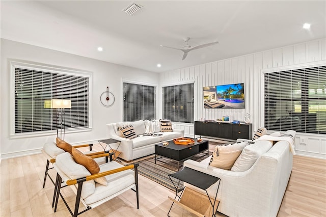 living room with light hardwood / wood-style flooring and ceiling fan