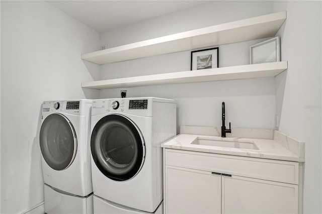 clothes washing area featuring cabinets, independent washer and dryer, and sink