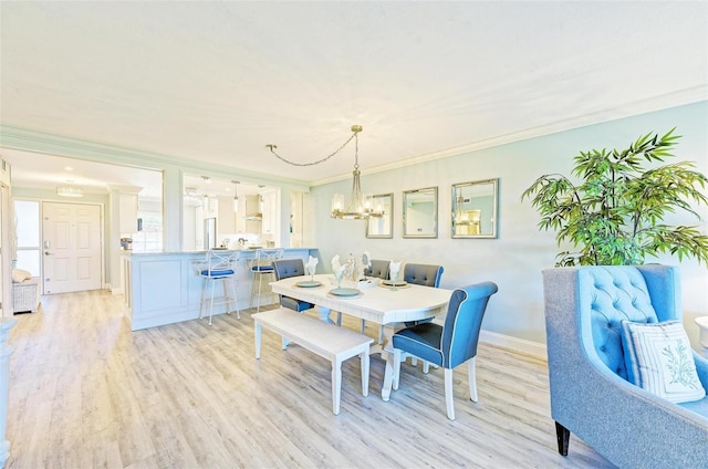 dining room featuring a notable chandelier, crown molding, and light hardwood / wood-style flooring