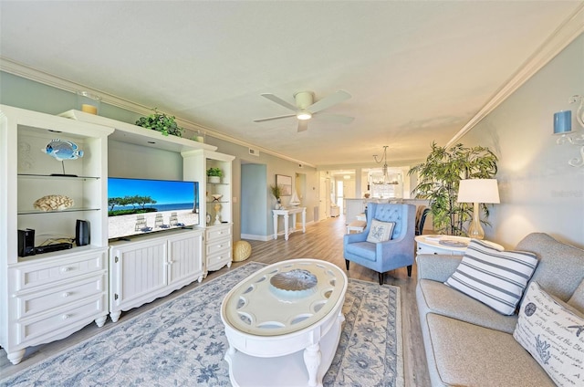 living room featuring crown molding, light hardwood / wood-style flooring, and ceiling fan