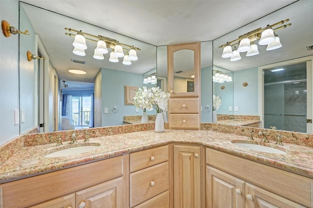 bathroom with a notable chandelier, vanity, and walk in shower