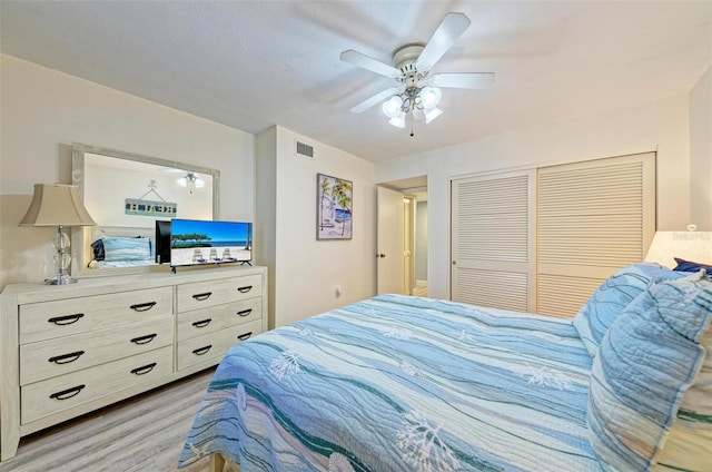 bedroom with ceiling fan, a closet, and light hardwood / wood-style flooring