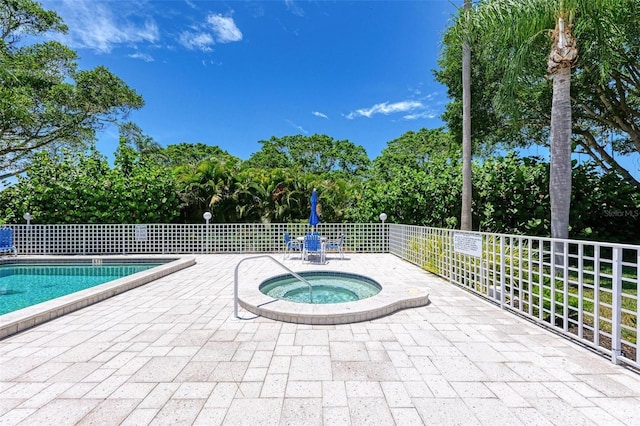 view of swimming pool with a patio and a hot tub