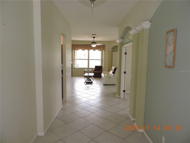 hallway featuring ornate columns and light tile patterned floors