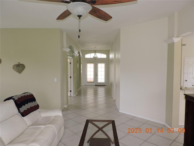 tiled living room with ceiling fan and french doors