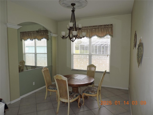 tiled dining area featuring a healthy amount of sunlight and a chandelier