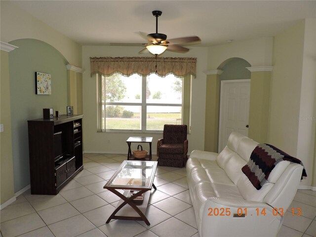 tiled living room with decorative columns and ceiling fan